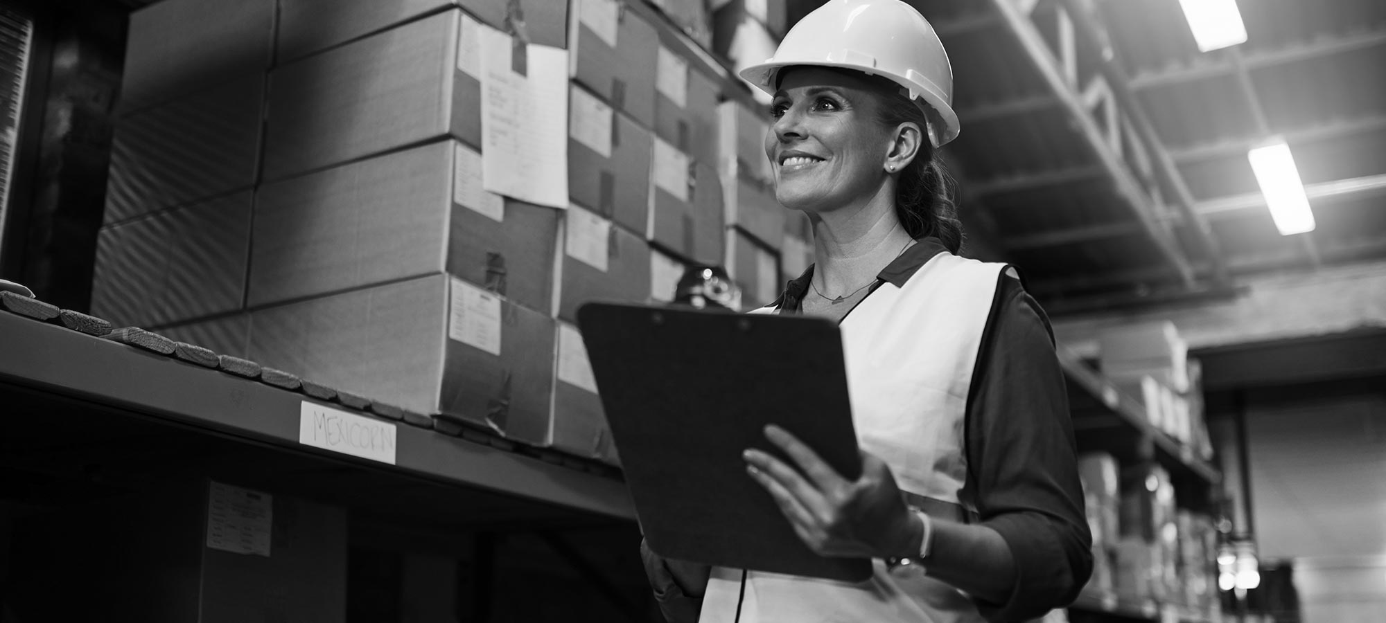 A woman supplier with a helmet and clipboard.