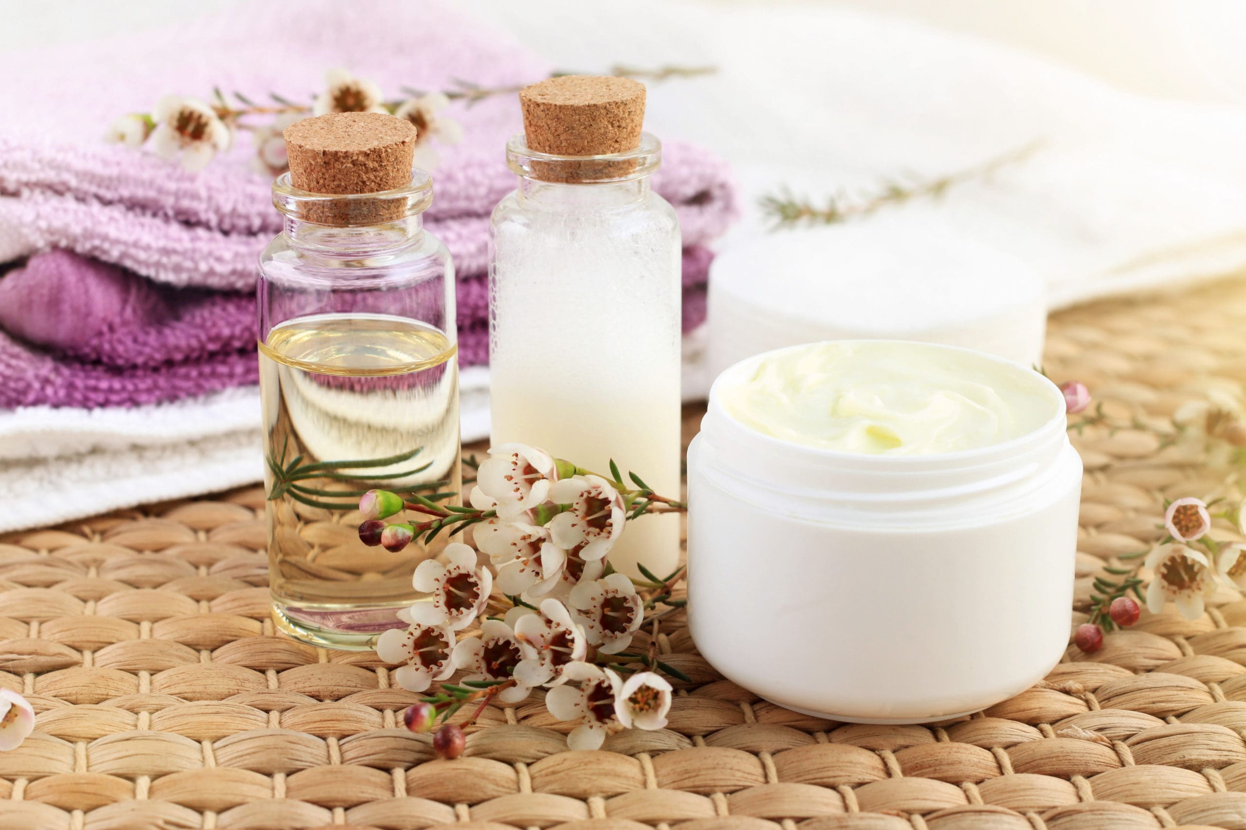 Bottles of natural oils sits next to jar of butter cream