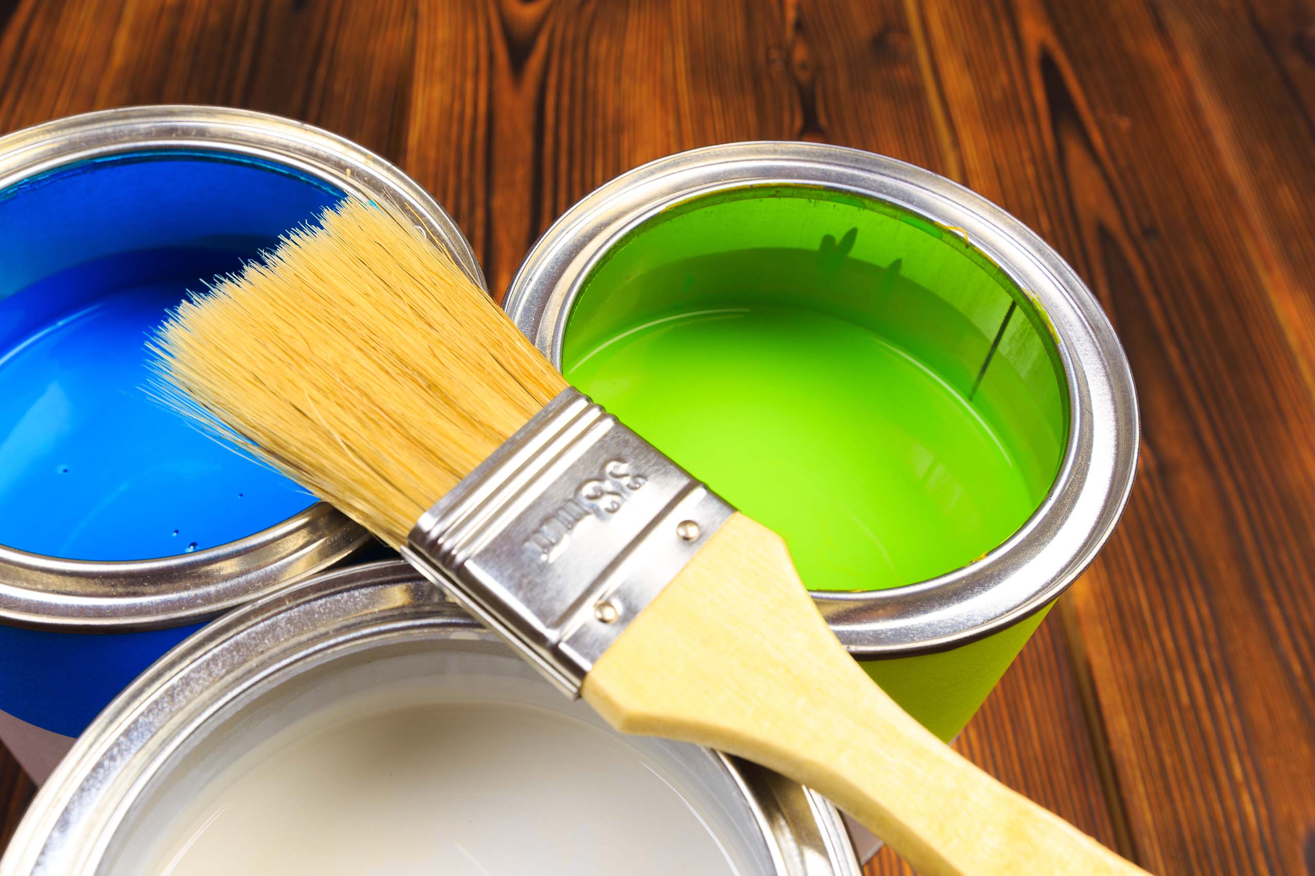 Paint brush on three open paint cans - preservatives