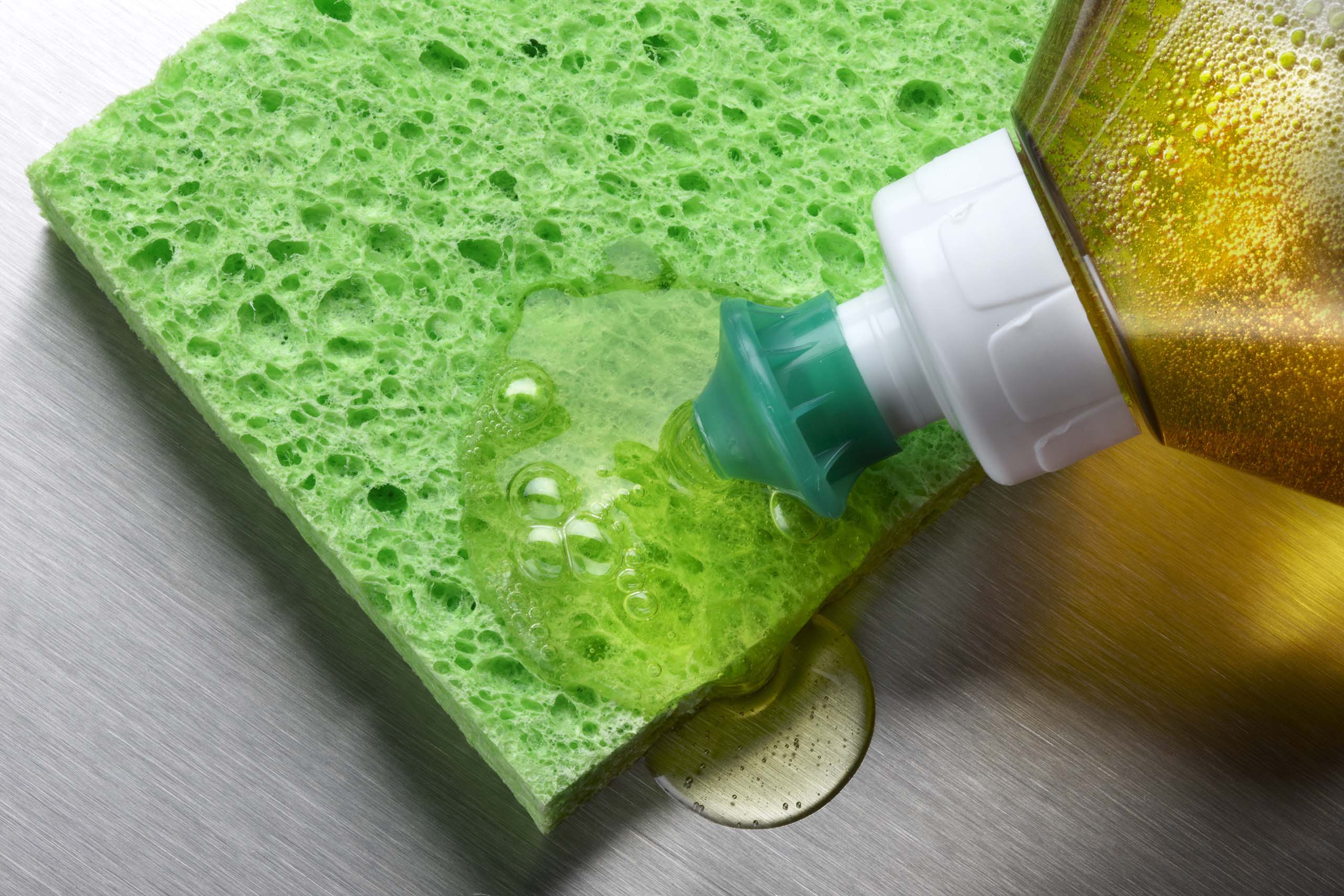Squirting soap on a green sponge